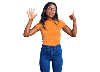 Young indian girl wearing casual clothes and glasses showing and pointing up with fingers number six while smiling confident and happy.