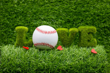 Baseball is on green grass background with love for Valentine's Day