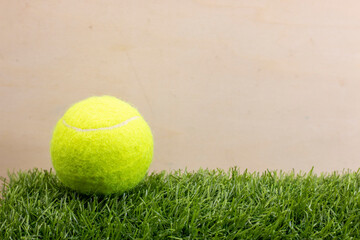 Tennis ball is on wooden background
