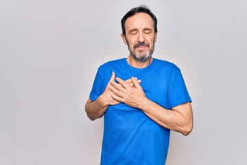 Middle age handsome man wearing casual t-shirt standing over isolated white background smiling with hands on chest, eyes closed with grateful gesture on face. Health concept.