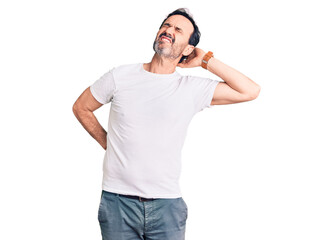 Fototapeta premium Middle age handsome man wearing casual t-shirt suffering of neck ache injury, touching neck with hand, muscular pain