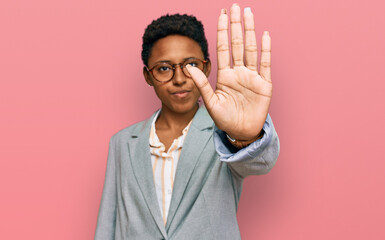 Young african american woman wearing business clothes doing stop sing with palm of the hand. warning expression with negative and serious gesture on the face.