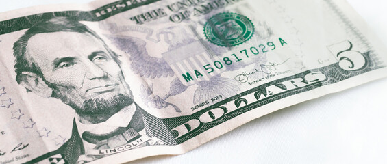 Dollar ( USD ). Money of United States of America. Five dollar bill in close-up with white...