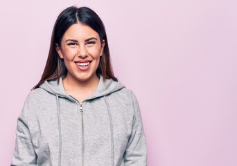 Fototapeta premium Young beautiful sporty woman wearing sportswear standing over isolated pink background with a happy and cool smile on face. Lucky person.
