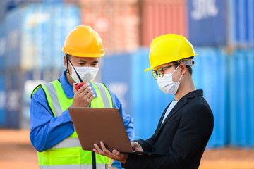 Engineer or Foreman Talk to an Asian businessperson about loading containers from a cargo ship.
