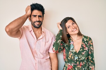 Beautiful young couple of boyfriend and girlfriend together confuse and wonder about question. uncertain with doubt, thinking with hand on head. pensive concept.