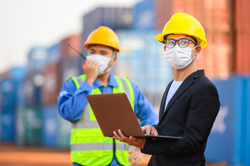 Engineer or Foreman Talk to an Asian businessperson about loading containers from a cargo ship.