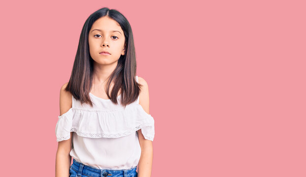 Beautiful Child Girl Wearing Casual Clothes Relaxed With Serious Expression On Face. Simple And Natural Looking At The Camera.