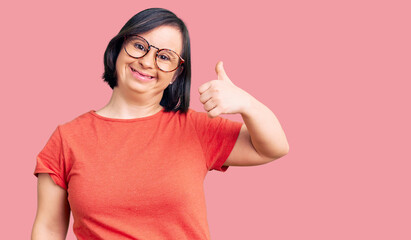 Brunette woman with down syndrome wearing casual clothes and glasses smiling happy and positive,...