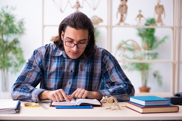 Young male teacher paleontologist in the classroom