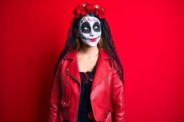 Woman wearing day of the dead costume over red smiling looking to the side and staring away thinking.