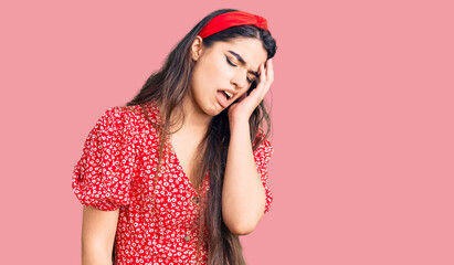 Brunette teenager girl wearing summer dress yawning tired covering half face, eye and mouth with hand. face hurts in pain.