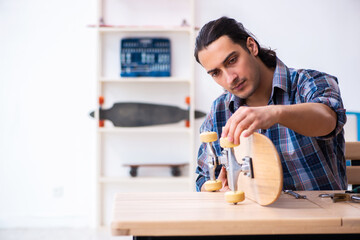 Young man repairing skateboard at workshop