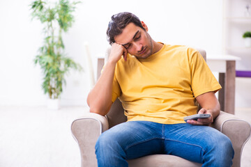 Young man watching tv at home
