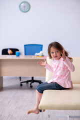 Naklejka premium Small girl waiting for doctor in the clinic