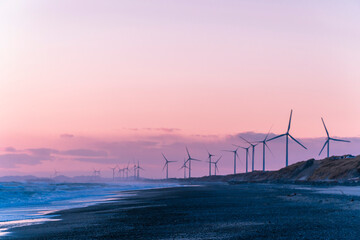   静岡県御前崎市の浜岡砂丘・海沿い浜辺の日没時の風力発電機群