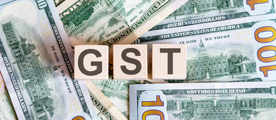 Wooden cubes with the abbreviation GST on dollar