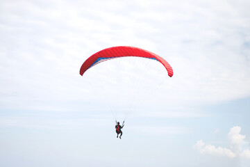 Red parachute landing on windy day..