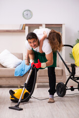 Young male contractor cleaning the house with his small daughter