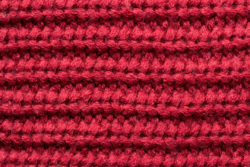 Fototapeta premium Red knitted fabric as an abstract texture. Knitting, elastic band pattern, English elastic band. Close-up. 