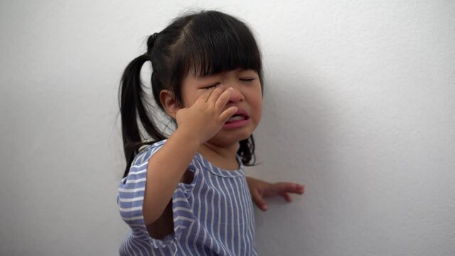 A Litter Asian girl sitting in room conner and crying after Punished by the blackout.