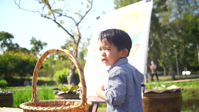 Little boy drawing imgae of flower in city park outdoor activity