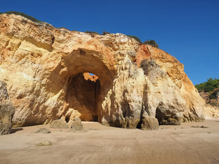 Praia da Vau with a cave with a hole to the sky in Portimao at the Algarve coast of Portugal