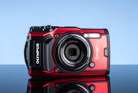Olympus Tough red compact camera on isolated blue background.