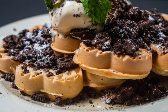 Chocolate waffles with chocolate biscuit slices sprinkled and given vanilla ice cream