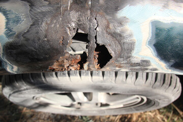 Metal corrosion on a car fender, rust hole. car body repair. Top view.