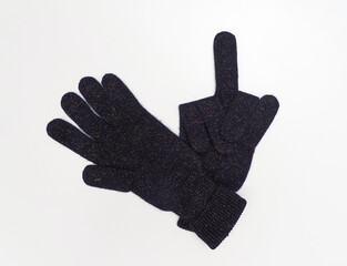Warm woolen gloves with lurix on a white background. Raised middle finger.