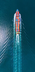 Aerial portrait view of smart cargo ship with contrail in the ocean sea ship carrying container...