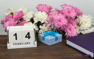 Desktop calendar with the date of February 14 and a bouquet of beautiful flowers. Delicate chrysanthemums for Valentine's Day.