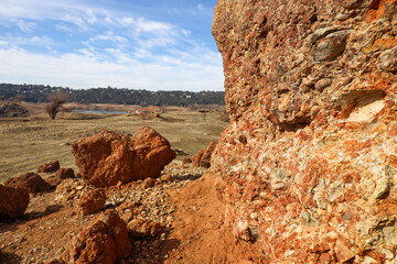 View of Red Conglomerate Rock with Forested Hill and Houses in the Background from Rattlesnake Bar...