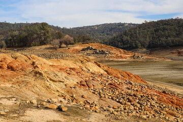 Red Rock Slope with River Stones Below Blue Sky with Wispy Clouds Along the North Fork of the American River California 