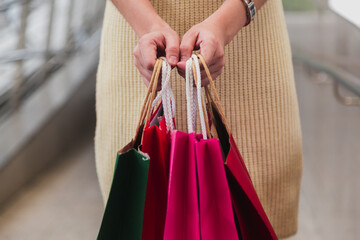 Closeup of woman holding shopping bags on the street with copy space.