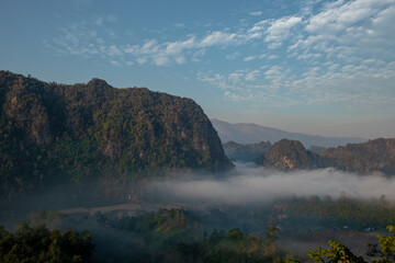 Mountain views and mist flowing through the gorge, clear sky. Mea Usu Cave, Tak in Thailand.