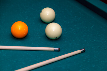 Billiard balls and cue on pool table. Russian billiards. Close-up of items for the game. Background space. Concept of sports games. Place for an inscription or logo. Copy space for site or banner