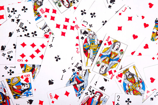 Playing cards scattered on table. Background of scattered deck of cards filling entire space of image. Top view, close-up. Copy space for site or banner