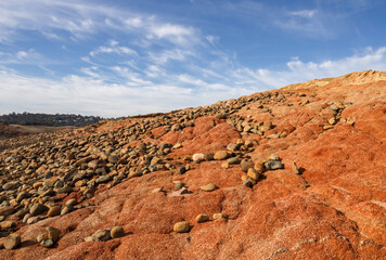 Red Rock Slope with River Stones Below Blue Sky with Wispy Clouds Along the North Fork of the American River California 