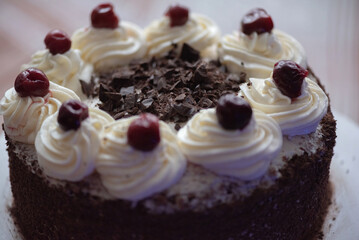 Black forest cherry cake close-up. Sponge cake with chocolate and cherries.