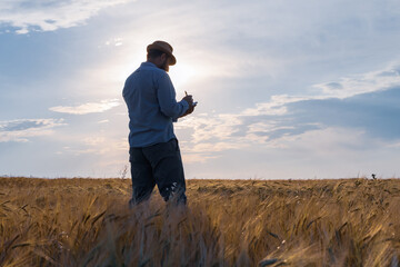a man farmer in a hat stands on the field and keeps a record of planning work for the day