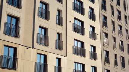Fototapeta premium Fragment of modern luxury residential apartment, home house building concept. Modern apartment building on a sunny day with a blue sky.