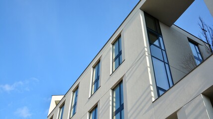 Obraz premium Fragment of modern luxury residential apartment, home house building concept. Modern apartment building on a sunny day with a blue sky.