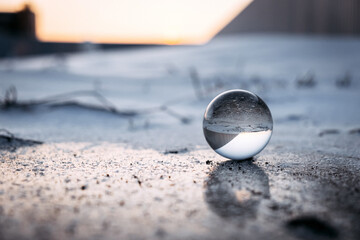 glass transparent ball on an ice crust in winter, reflected on ice. severe frost, cold