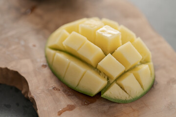 Ripe green mango sliced on olive wood board