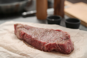 closeup raw seasoned new york steak on concrete countertop background