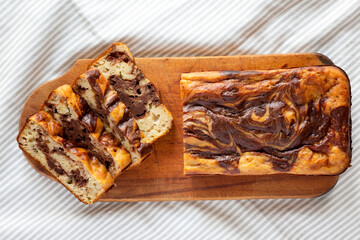 Homemade Chocolate Banana Bread on a rustic wooden board on a white wooden background, top view. Flat lay, overhead, from above.