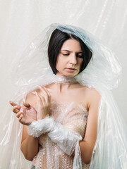 Female slavery. Human trafficking. Woman kidnap. Art portrait of disturbed hostage bride in white...