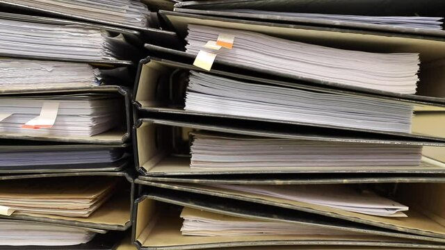 Close-up old files and papers of big folders in archives of business financial documents.